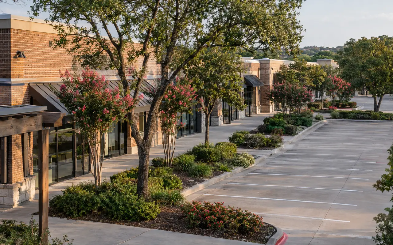 Elevated view of suburban commercial buildings with wide sidewalks and landscaped parking.